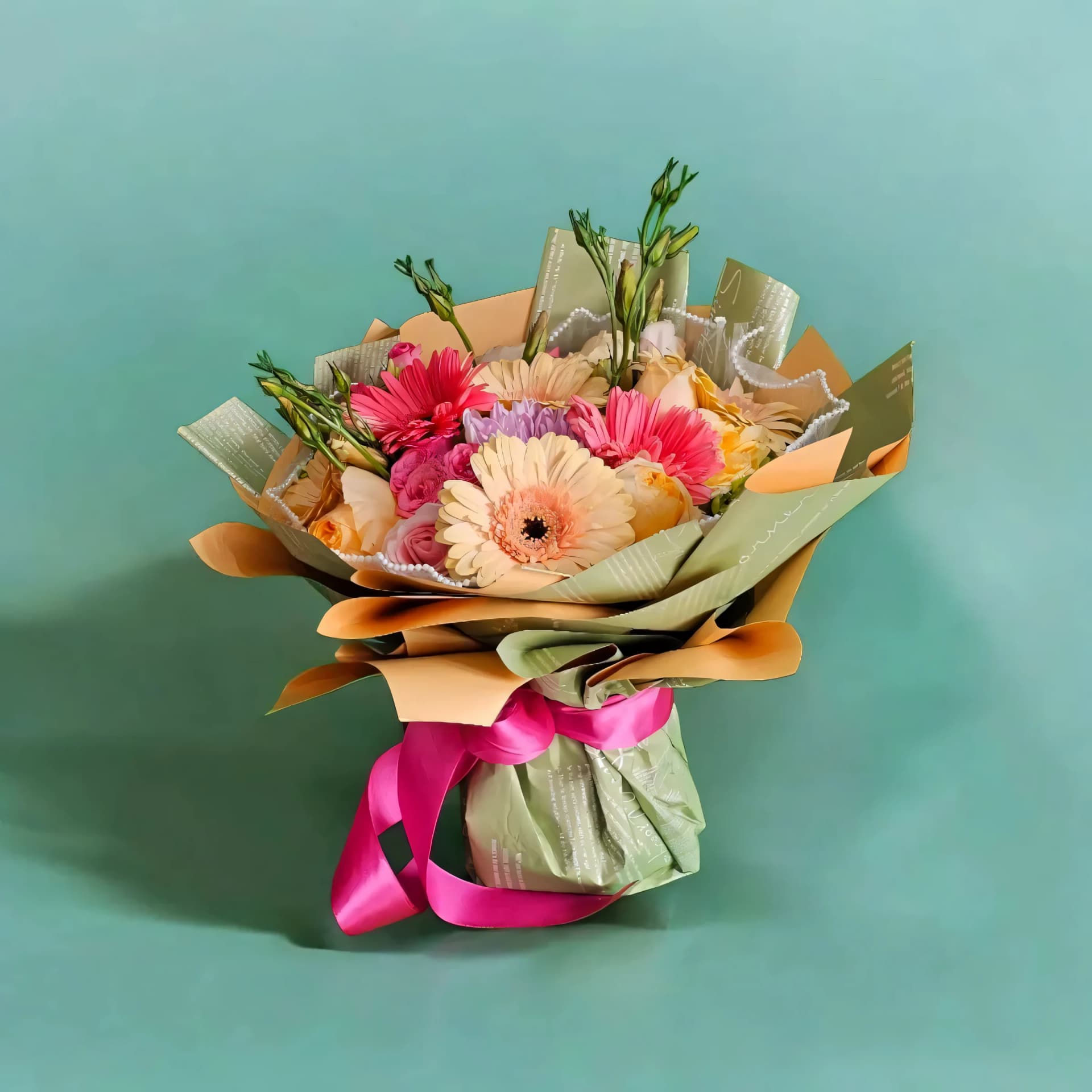 Ramo de gerberas rosas envuelto en papel coreano con listón